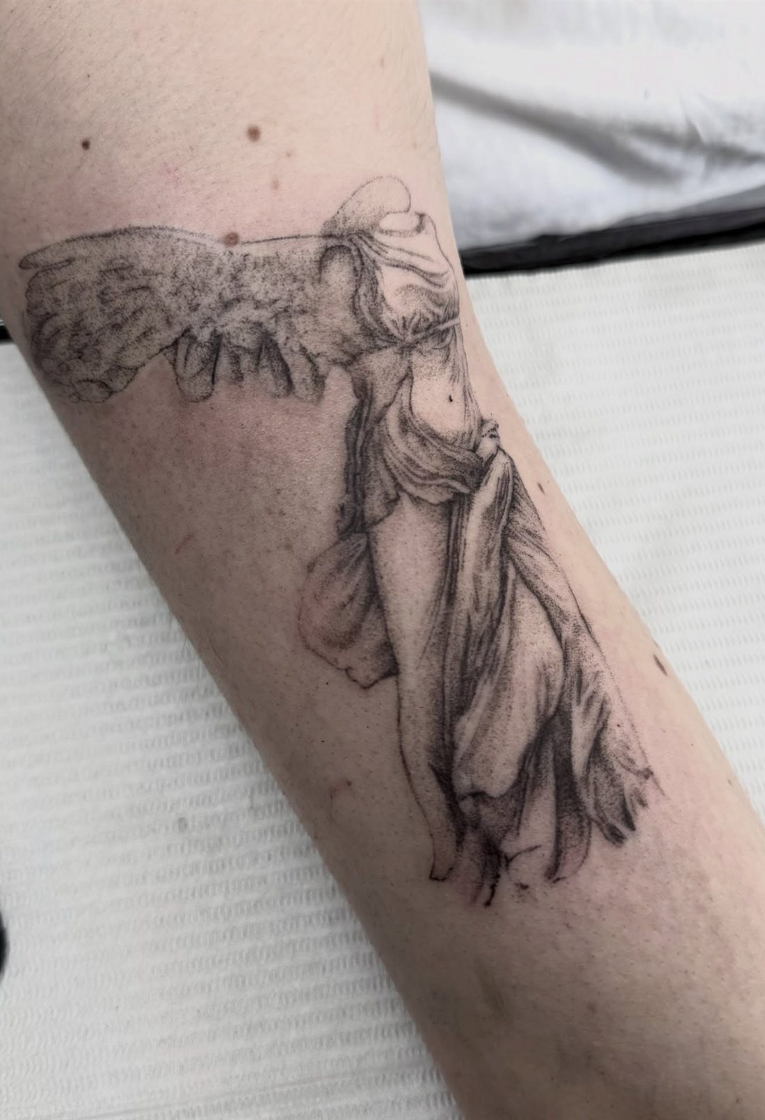 Tatouage de la Victoire de Samothrace en semi-réalisme sur l’avant-bras
