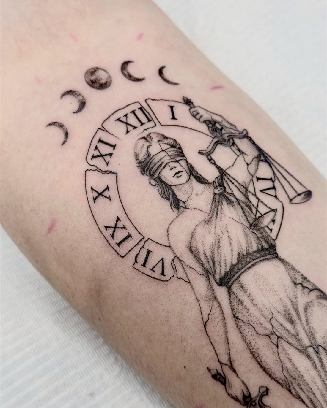 Tatouage de Thémis, déesse de la justice, avec cadran romain et phases de lune